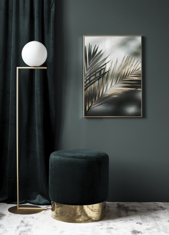  – Fotografia de duas folhas de palmeira em verde e dourado, com a luz do sol a incidir na pedra que está de fundo