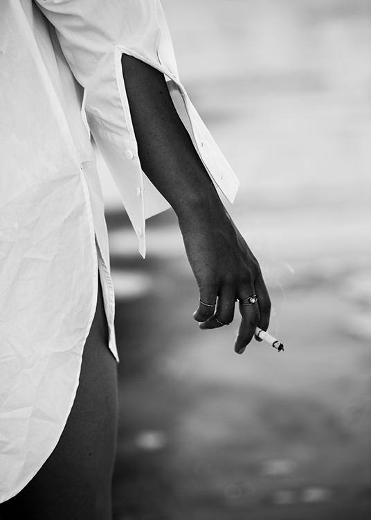 – Fotografia em preto e branco de uma rapariga a segurar um cigarro perto da água