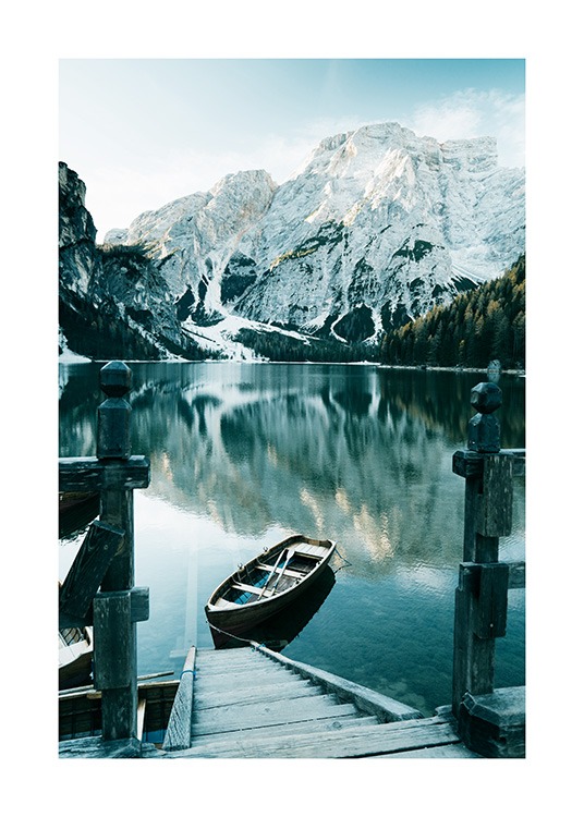  – Fotografia de um barco num lago junto a uma escada de madeira, com neve a cobrir as montanhas e árvores de fundo
