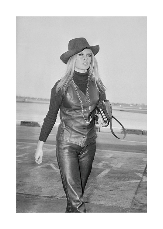  – Fotografia a preto e branco da atriz Brigitte Bardot a vestir uma roupa de couro e um chapéu