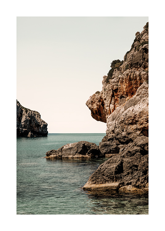  – Uma fotografia de rochas que dão lugar ao mar
