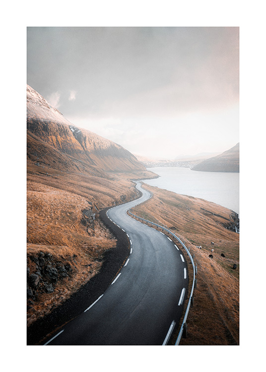  – Fotografia de uma paisagem de montanha com uma estrada no meio e um lago ao lado